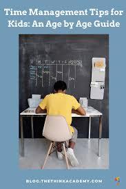 A person sits at a desk in front of a blackboard with a calendar on it.